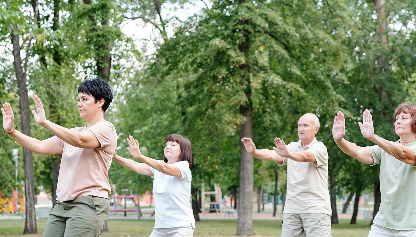 eine Gruppe von Senioren praktiziert qi gong im Park